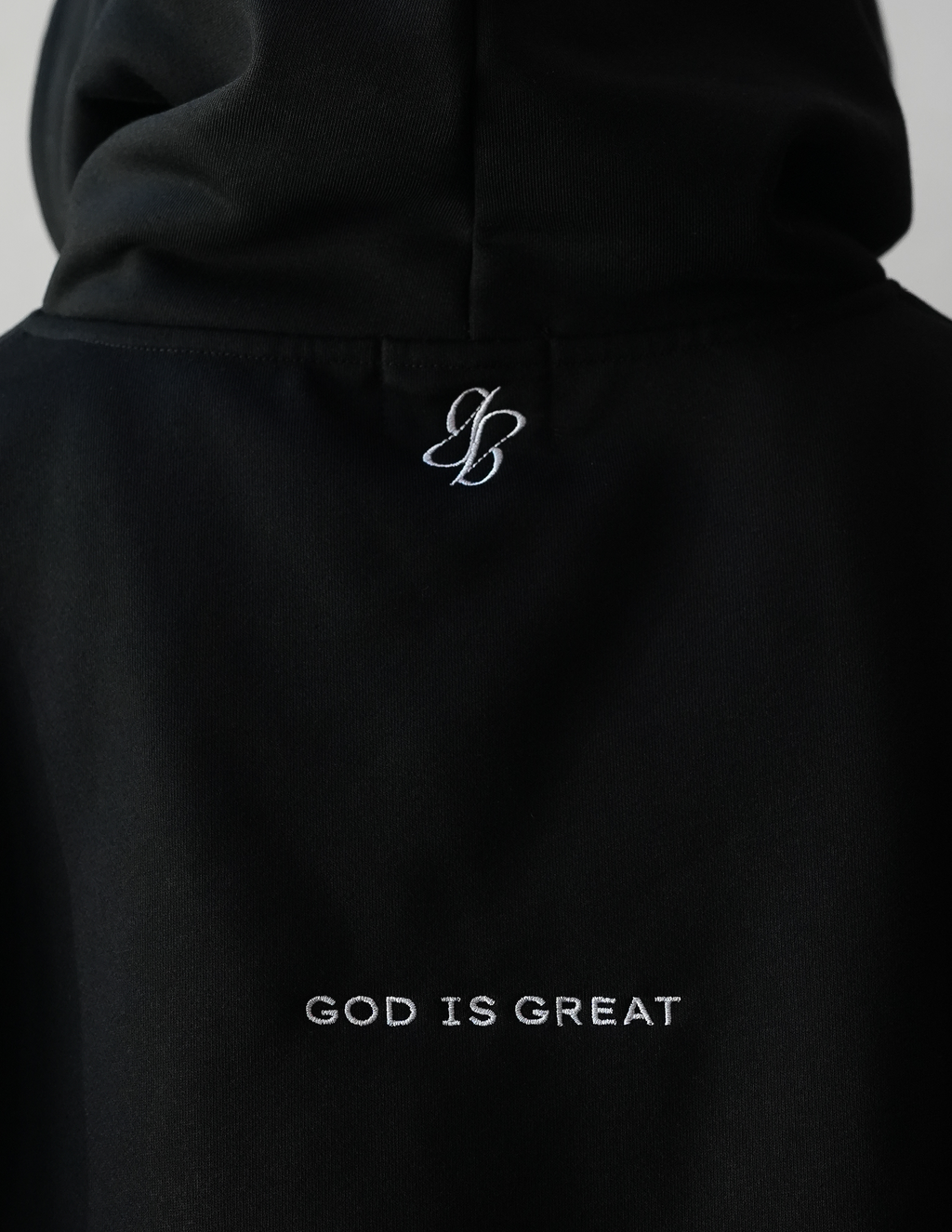 Black hoodie with 'God is Great' text and logo on a plain background