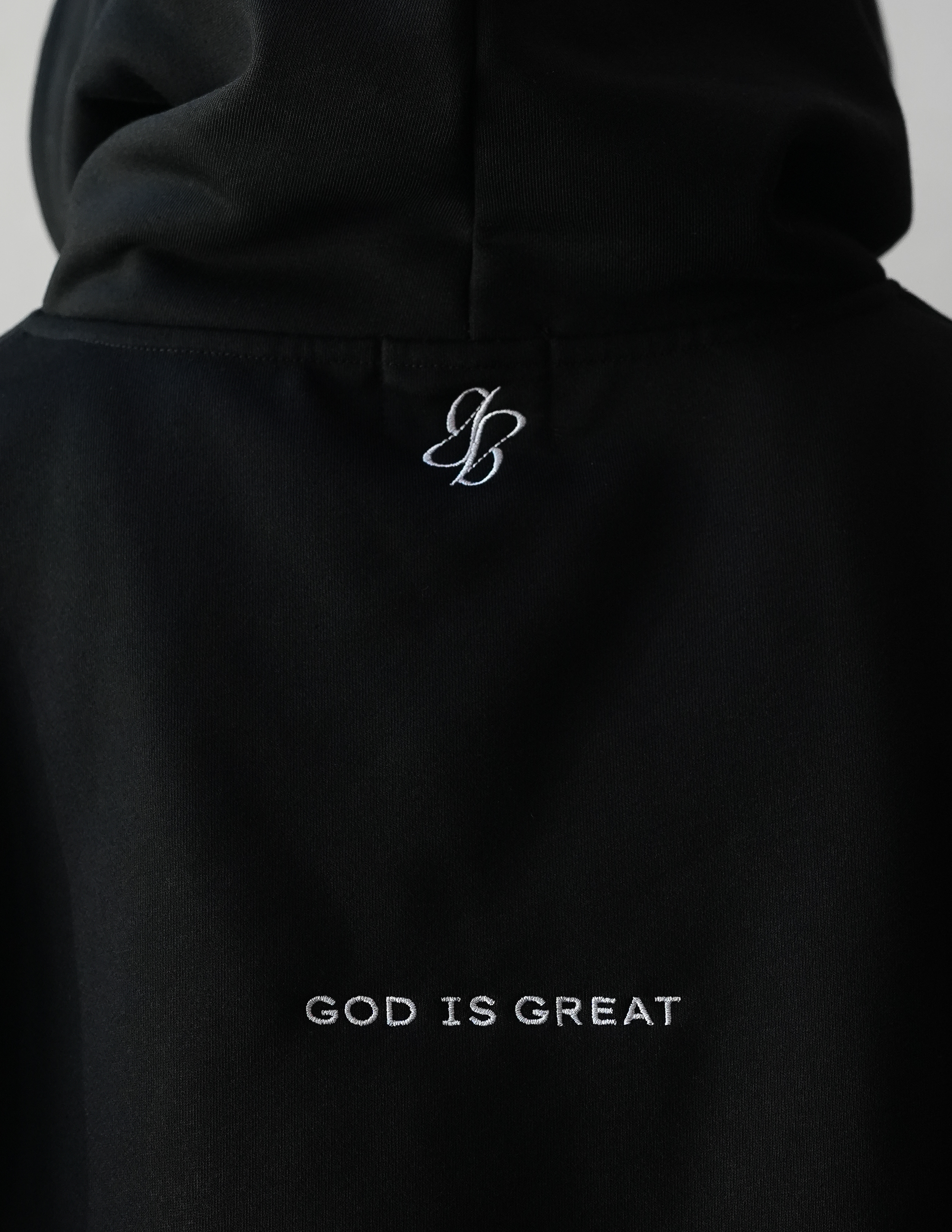 Black hoodie with 'God is Great' text and logo on a plain background
